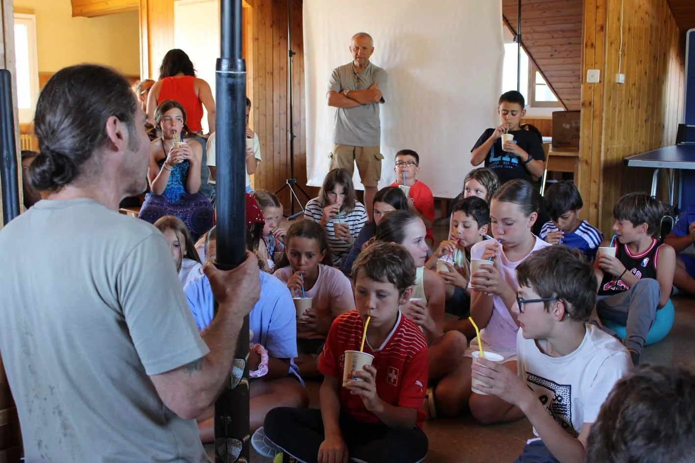 Groupe d’enfants assis en cercle pendant une activité au camp